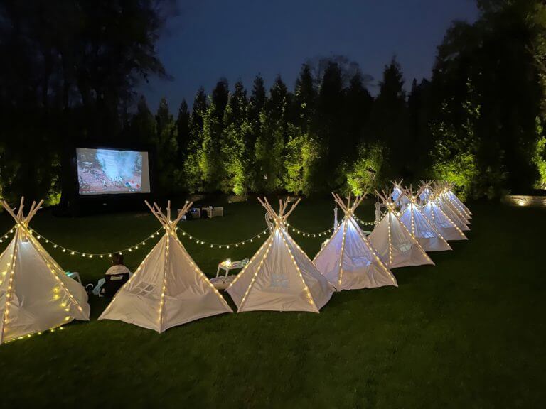 movie night backyard party with teepee tents and string lights