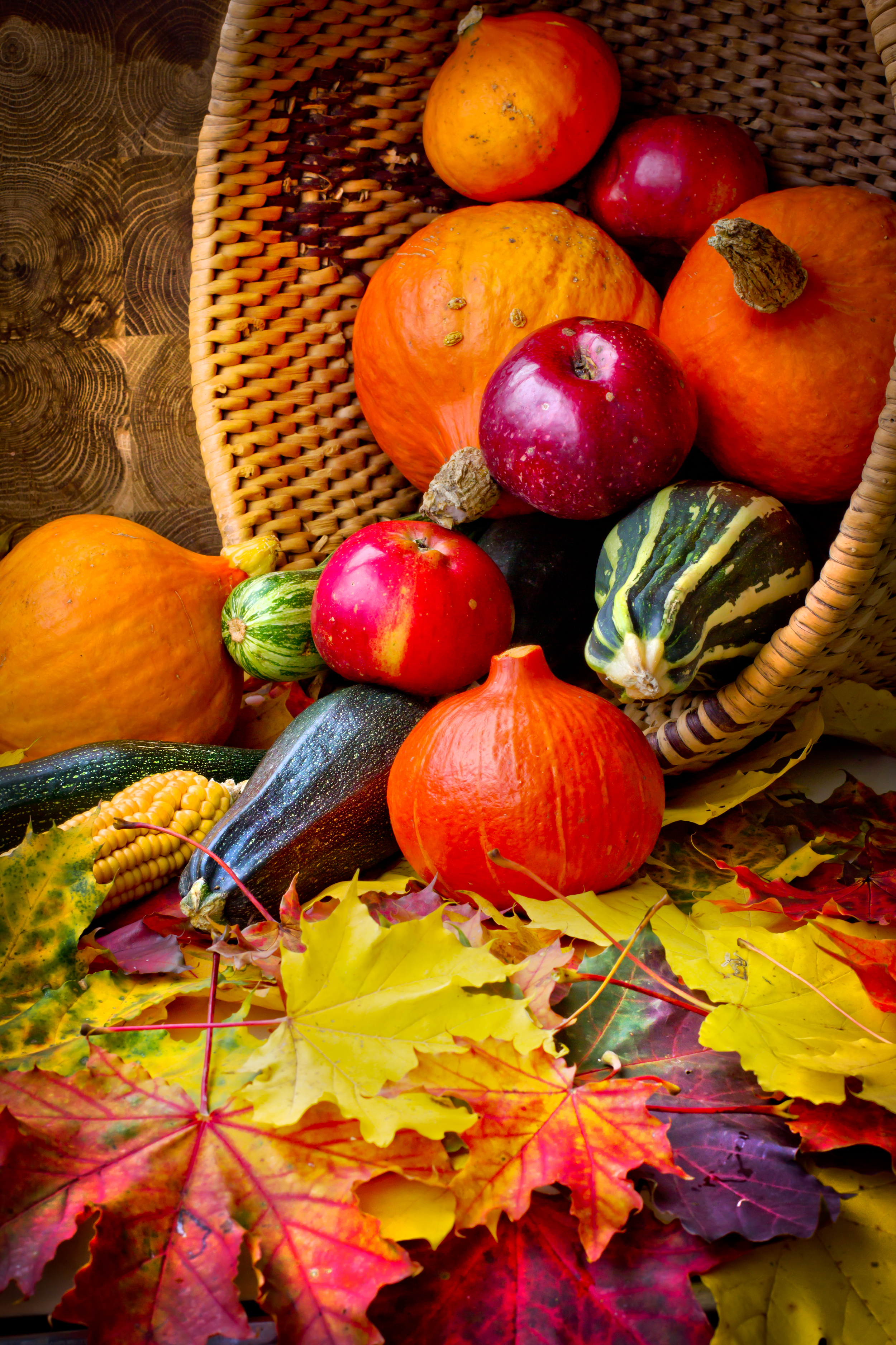 fall seasonal harvest basket including apples, squash, pomegranates